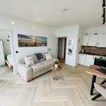 Wohnung mit Wohnzimmer, Küche und Schlafzimmer. Holzfußboden und weiße Wände.