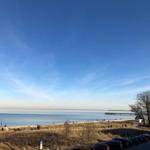 Strand mit Steg und Parkplatz unter klarem Himmel