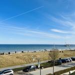 Blick auf Strand, Meer und Parkplatz mit Autos.