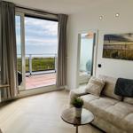 Wohnzimmer mit Sofa, Blick auf Terrasse und Meer.