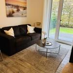 Wohnzimmer mit Sofa, Couchtisch und Blick auf den Garten.