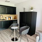 Kitchen with dining table, black cabinets, and living area with sofa.