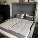 Double bed with gray bedding and wall art above the headboard.