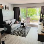 Living room with sofa, rug, and glass table. Access to terrace with garden view.
