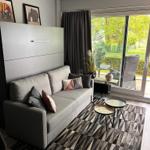 Living room with sofa, rug, and view of balcony