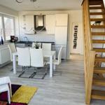 Küche mit Essbereich und Holztreppe zur oberen Etage.