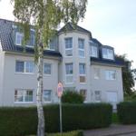 Modernes Mehrfamilienhaus mit Balkon und dunklem Dach