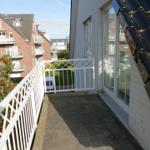 Terrasse mit weißer Brüstung und Sicht auf Wohngebiet.