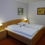 Ein Schlafzimmer mit Holzbett, Nachttischen und Wandbildern.