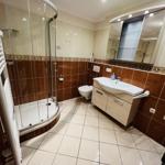 Badezimmer mit Dusche, Waschbecken und Toilette.