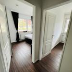 Zwei Schlafzimmer mit Holzboden und Fenstern