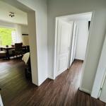Flur mit Holzboden, Tür zu Schlafzimmer und Blick in Esszimmer mit Tisch und Stühlen.