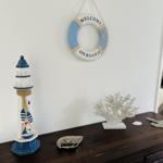Hölzerne Konsole mit Leuchtturm, Korallen und Rettungsringdekoration.