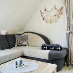 Living room with sofa, table, and wall decoration with fishing net.