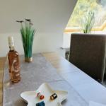 Table with bottle, bowl, and plant by window