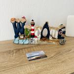 Welcome decoration with lighthouse and seal on wooden table