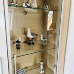 Glass display case with sailboat, seagull, and lighthouse models.