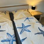 Double bed with starfish pattern, nightstand, and lamp