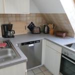 Kitchen with sink, dishwasher, stove, and oven under sloped roof