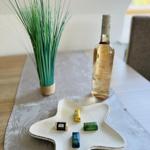 Table with bottle, chocolates, and plant. Star-shaped dish with sweets.