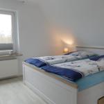 Bedroom with double bed, window, and bedside lamp.