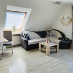 Living room with sofa, dining table, and skylight.