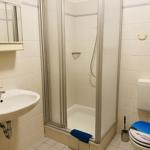 Badezimmer mit Dusche, Waschbecken und Toilette.