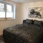 Schlafzimmer mit Bett, Fenster und Wandbild eines Stiers.