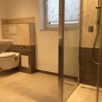 Badezimmer mit Dusche, Toilette und Waschbecken