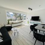 Living and dining area with sofa, dining table, and TV.