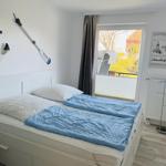 Bedroom with bed, window, and wall decor.