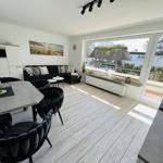 Living and dining area with view of balcony and garden.