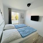 Bedroom with double bed, TV, and window to balcony.