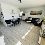 Living and dining area with sofa, table and chairs as well as kitchenette.