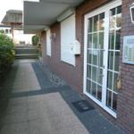 Entrance area with glass door, mailbox, and lantern on brick wall.