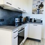 Modern kitchen with white cabinets, stainless steel appliances, and kitchen counter.
