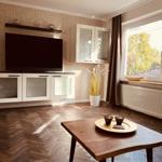 Wohnzimmer mit TV, Holzboden und Fensterblick auf Grün.
