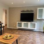 Wohnzimmer mit TV, Schrank und Holzboden