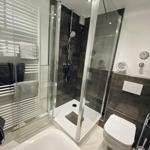 Badezimmer mit Dusche, Toilette und Badewanne.
