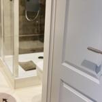 Badezimmer mit Dusche und Toilette hinter Tür