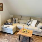 Ein Wohnzimmer mit Ecksofa, Holztisch und Himmelbett.