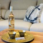 Auf dem Tisch steht eine Flasche Wein mit zwei Gläsern auf einem goldenen Tablett.