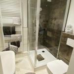 Badezimmer mit Dusche, Toilette und Heizung. Handtuchhalter und Bodenmatte mit Anker.