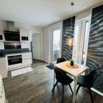 Küche mit Essbereich, Balkon und moderner Einrichtung.