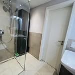 Badezimmer mit Dusche, Waschbecken und Tür