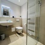 Badezimmer mit Dusche, Waschbecken und Toilette.