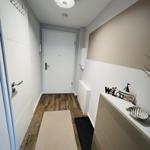 Flur mit Holzboden, Schuhregal, Willkommensdekoration und Tür.