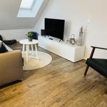 Wohnzimmer mit Sofa, Fernseher und Holzboden