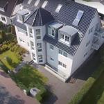 White villa with rooftop terraces and landscaped garden. 