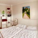 Bedroom with double bed, shelf, and window with blinds.